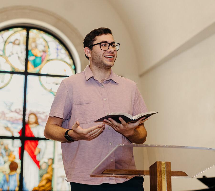 a student from the ministry leadership studies concentration in pastoral ministries program reads from the bible