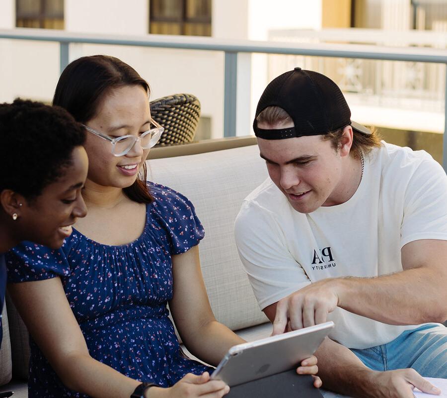 Students from the bachelor of general studies program study together on a balcony.